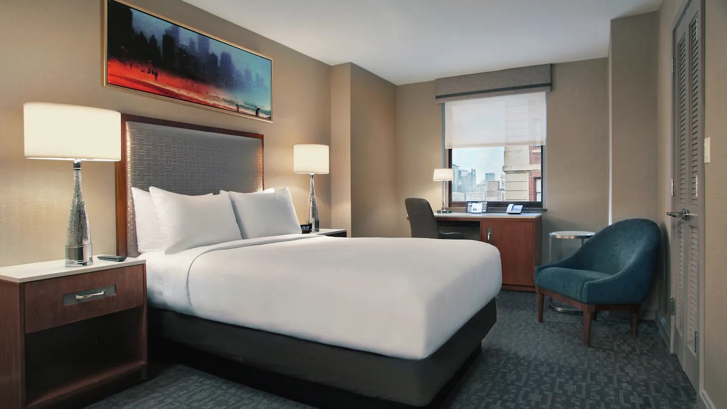 a hotel room with a bed and a chair