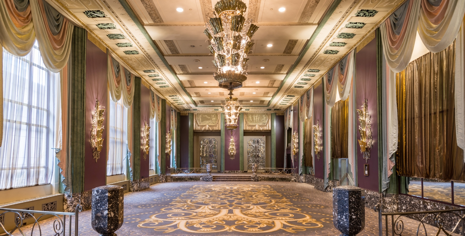 a large room with chandeliers and curtains