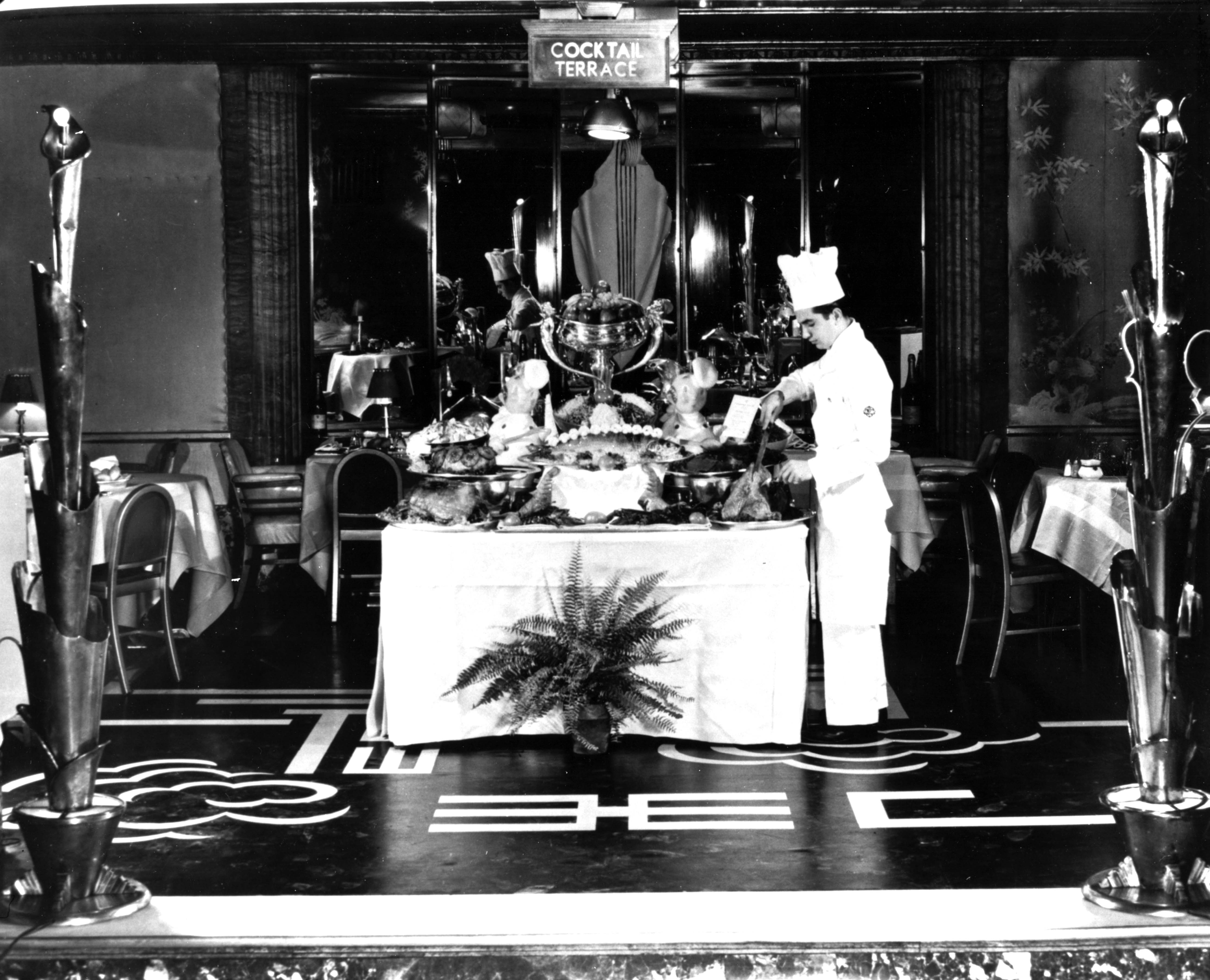 a chef standing behind a table