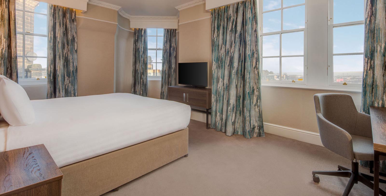 a room with a bed and a television