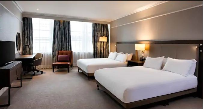 a room with two beds and a chair