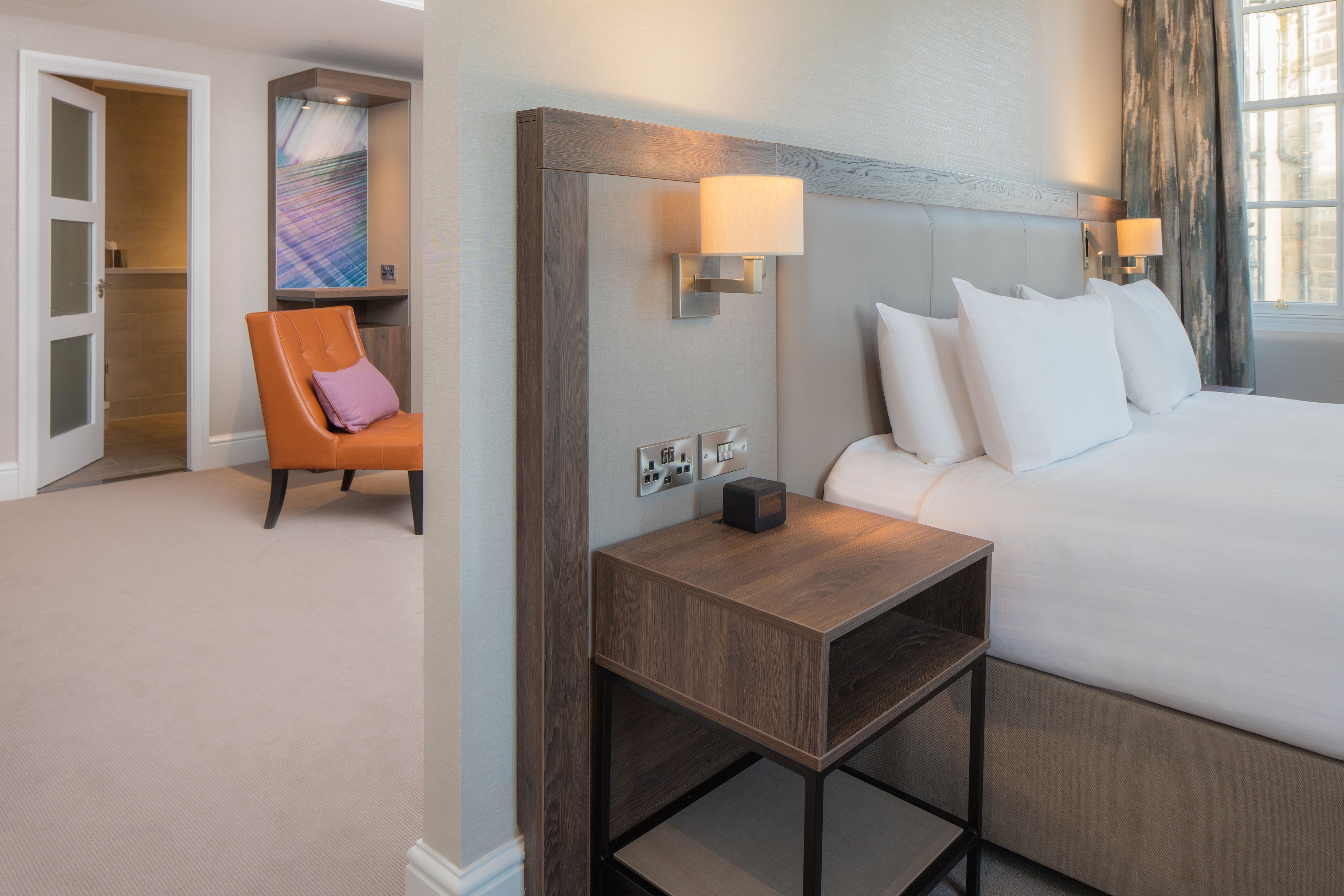 a bed with white pillows and a wood headboard