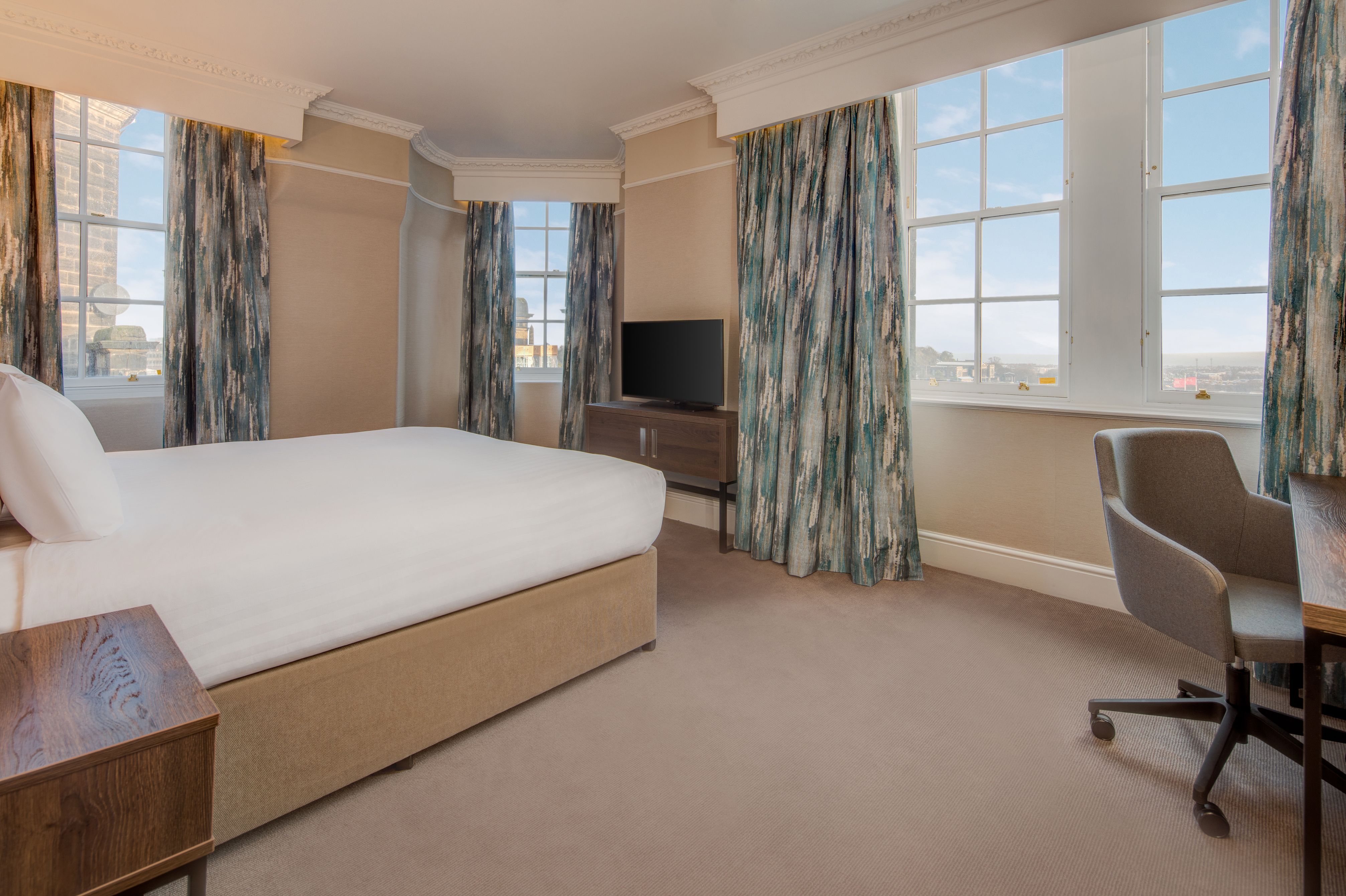 a room with a bed and a television