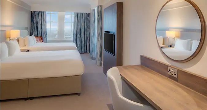 a room with a mirror and a bed