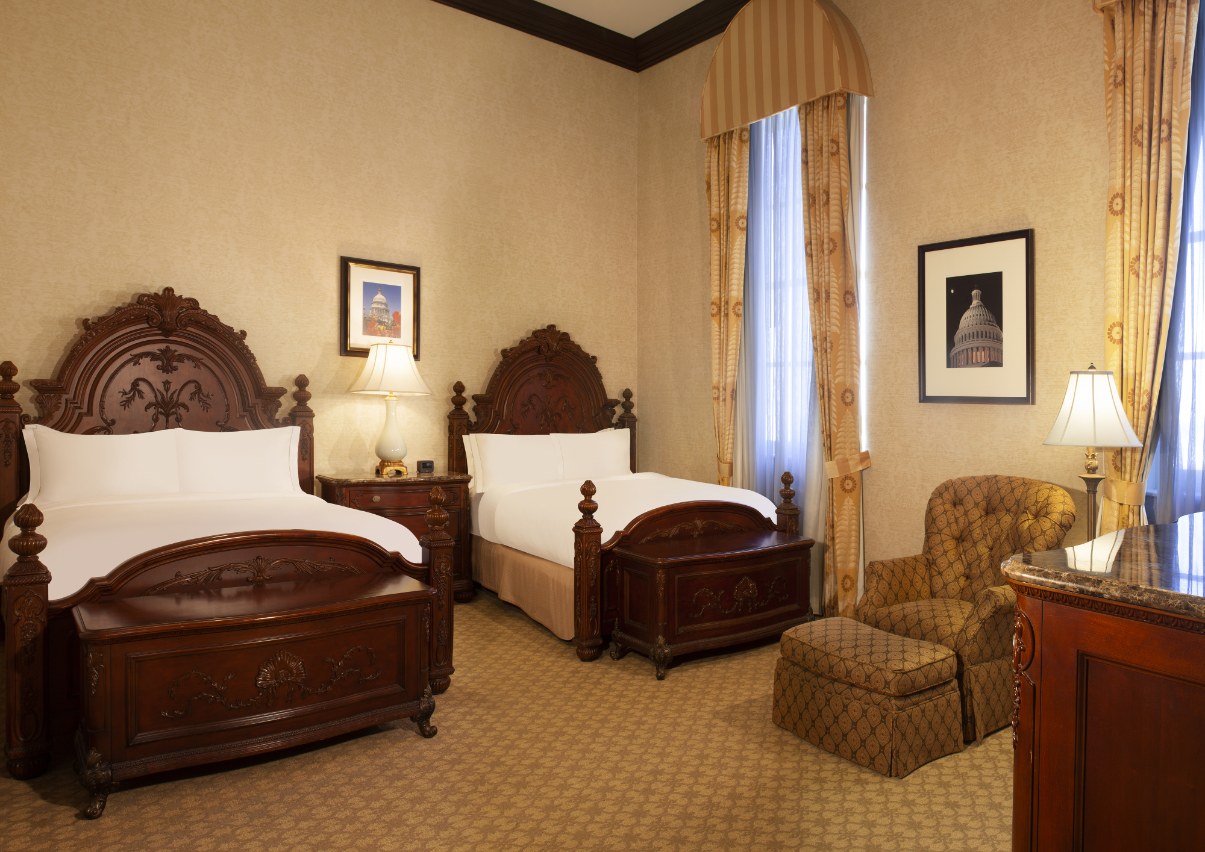 a room with two beds and a chair