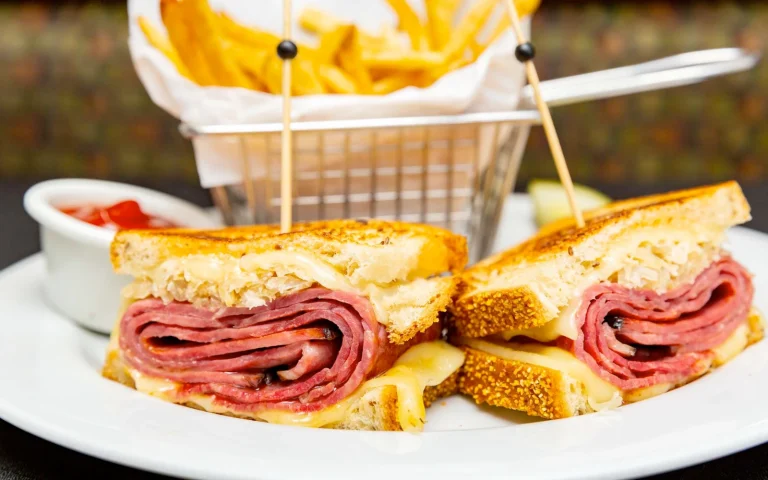 a plate of sandwiches with a basket of fries