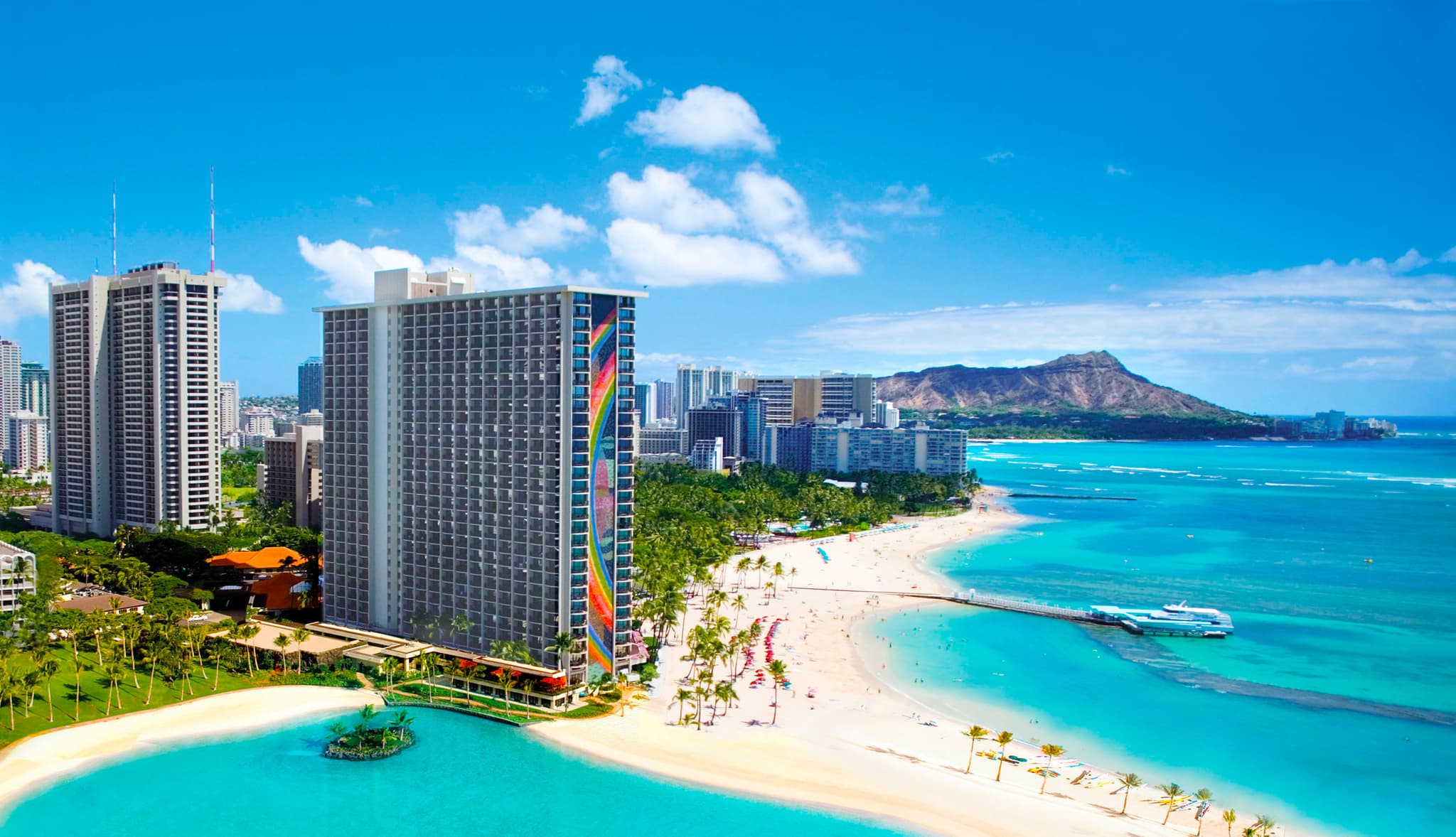a beach with a tall building and palm trees