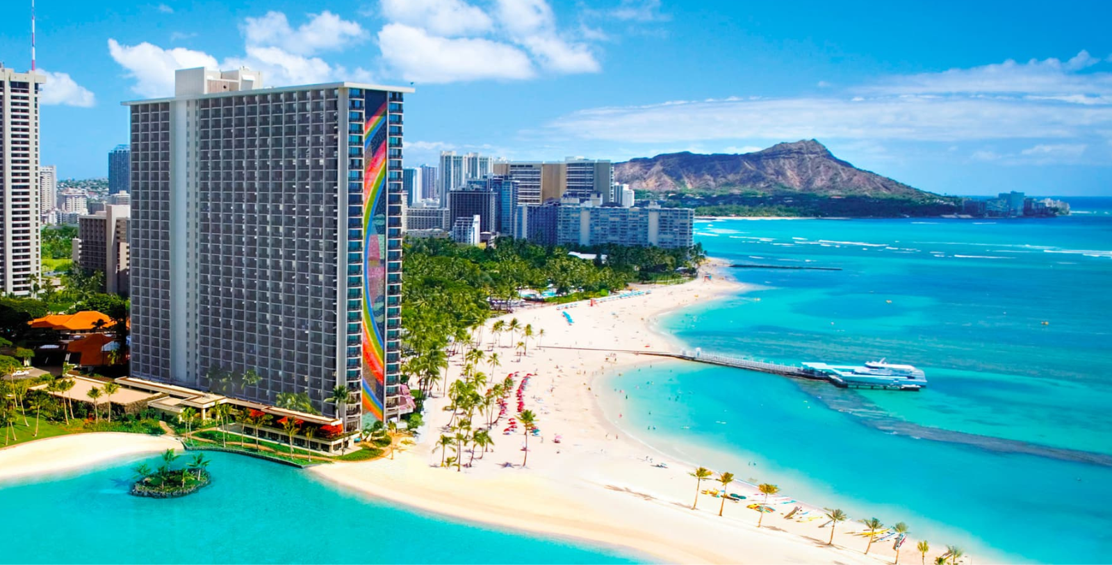 a beach with a tall building and palm trees