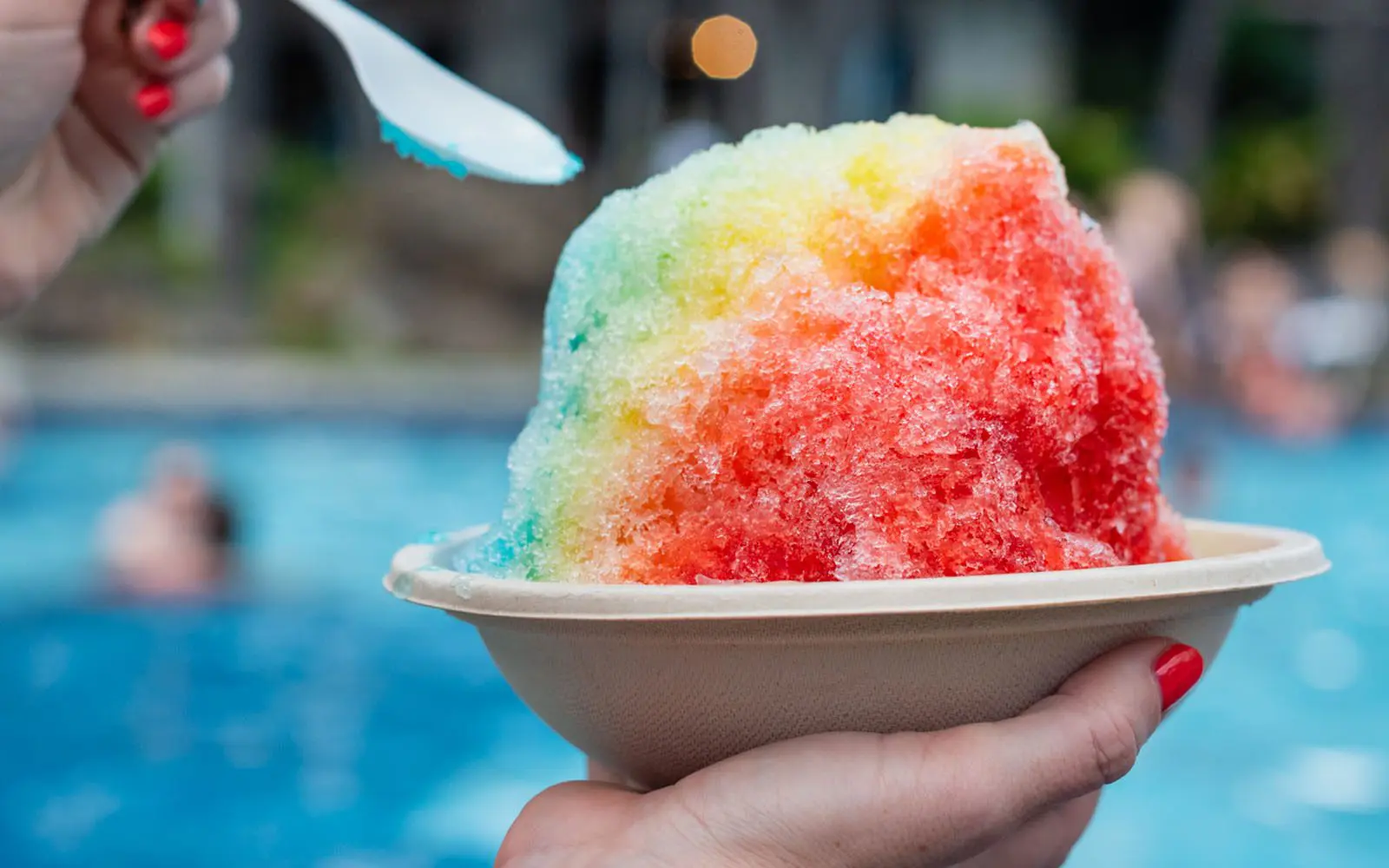 a hand holding a bowl of shaved ice