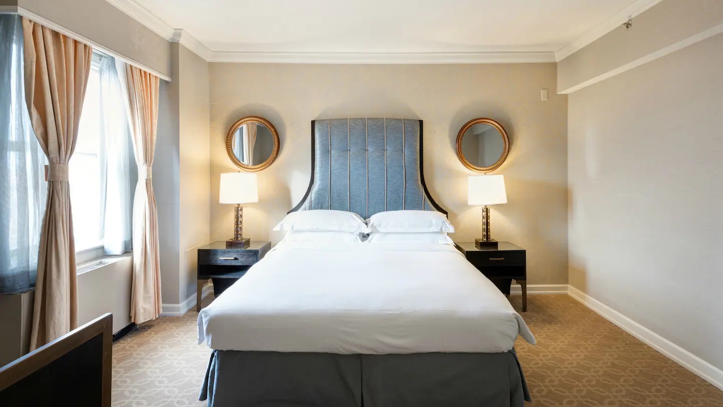 a bed with two mirrors above it