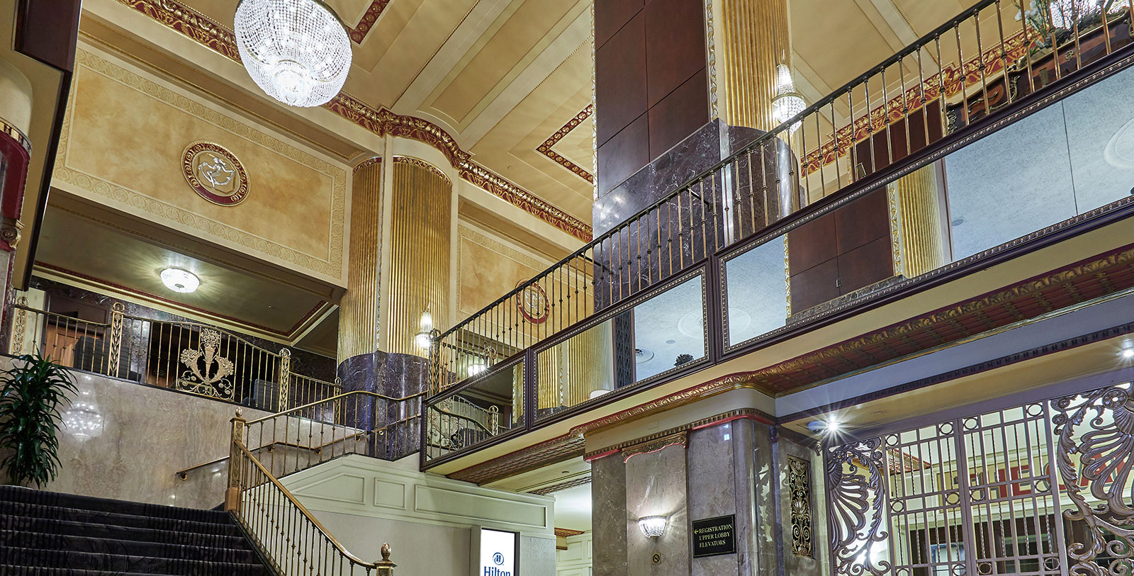 a staircase with a large pillar and a chandelier