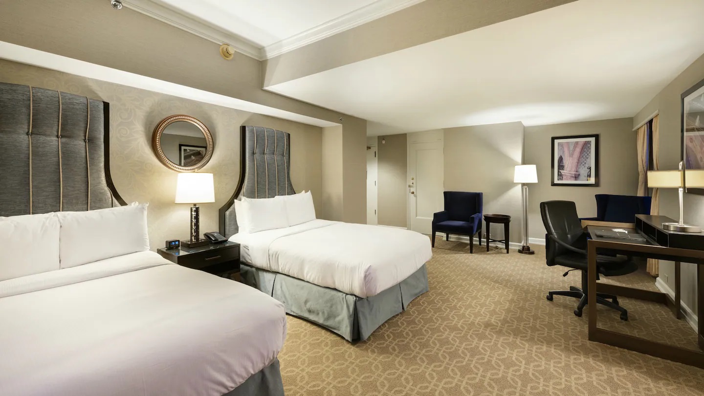 a hotel room with two beds and a chair