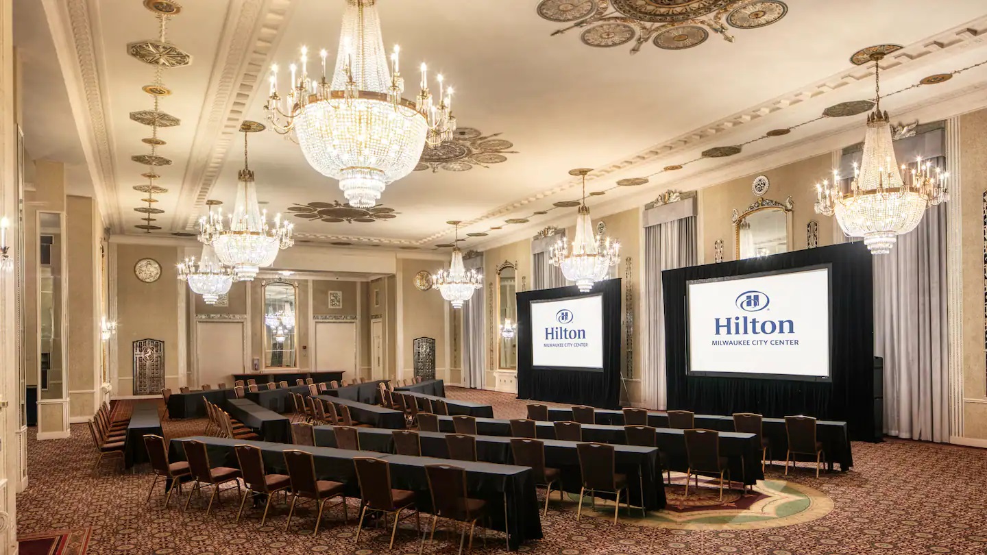 a room with a large screen and chandeliers