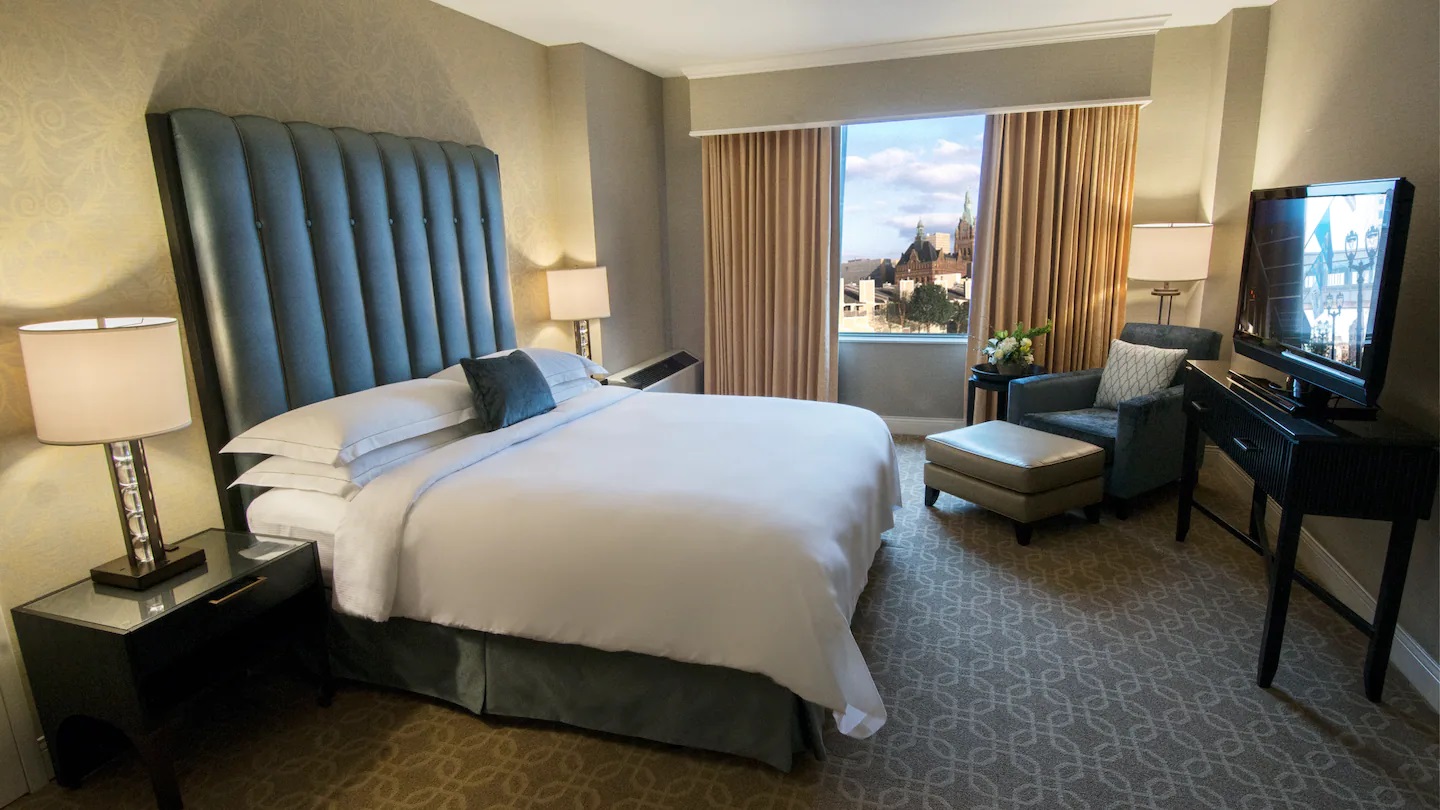 a hotel room with a large bed and a chair