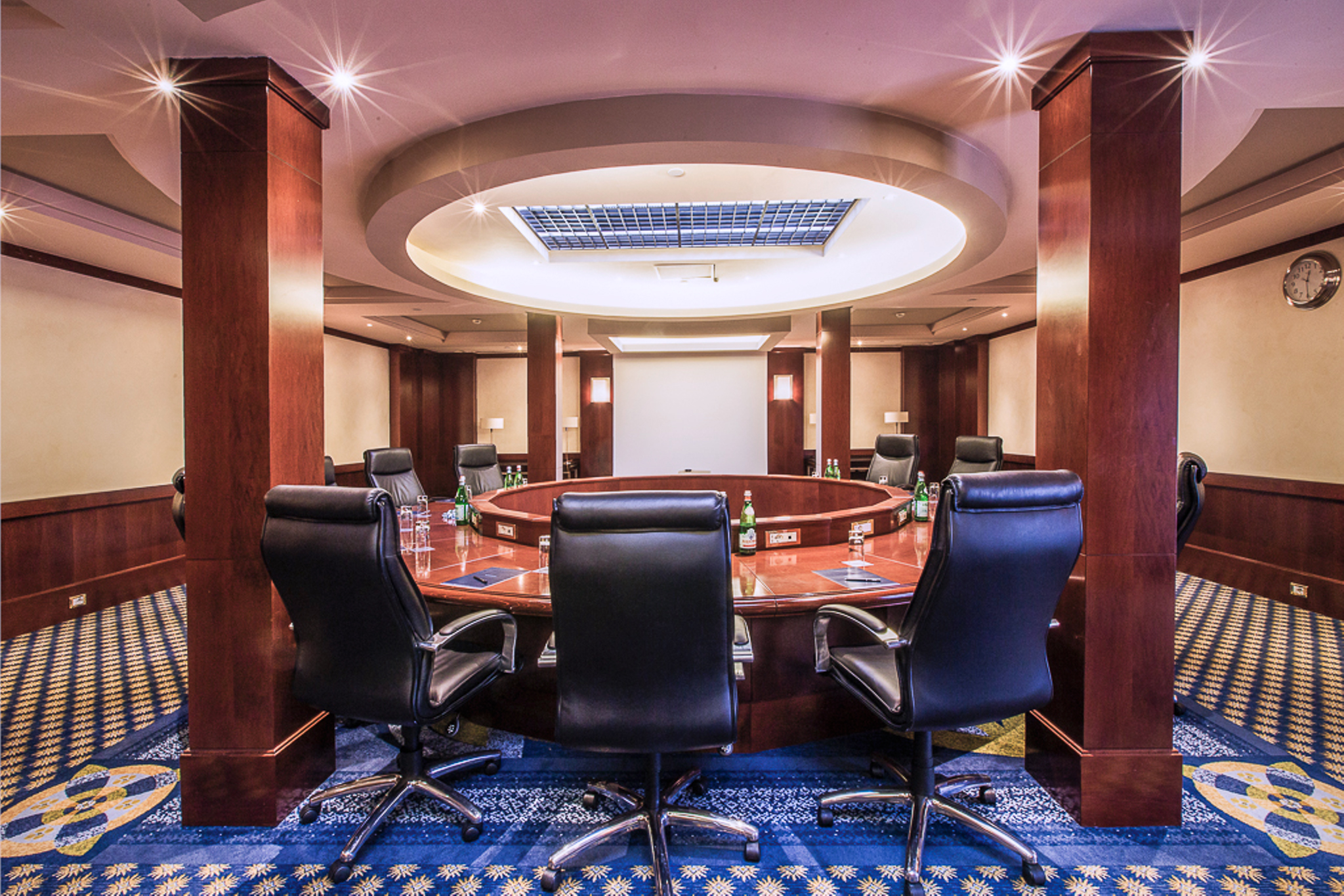 a conference room with a round table and chairs