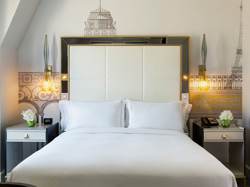a bed with white sheets and pillows
