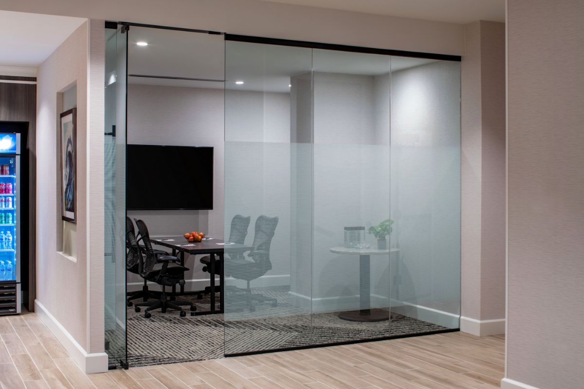 a glass wall with a table and chairs in the middle
