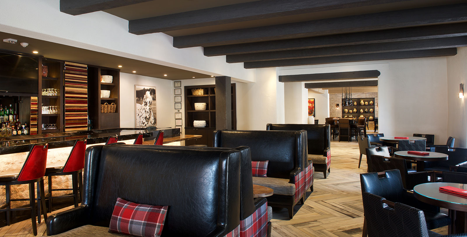a room with black couches and a wood floor