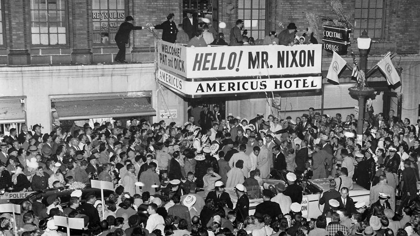 a large crowd of people outside a hotel