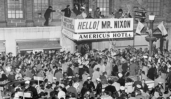 a large crowd of people outside a hotel