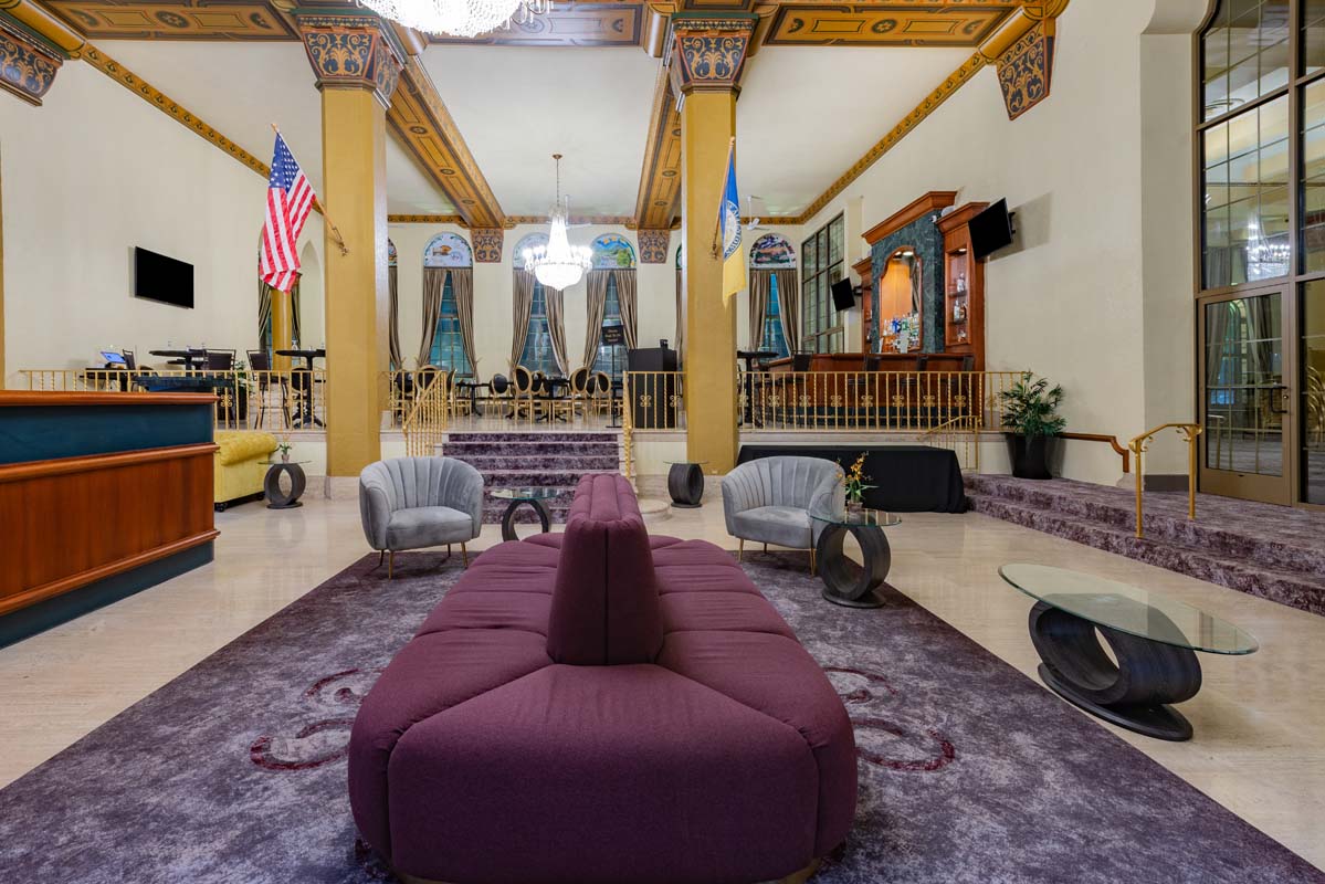 a room with a purple couch and chairs
