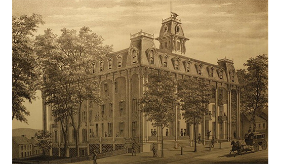 a large building with trees and people walking on the street