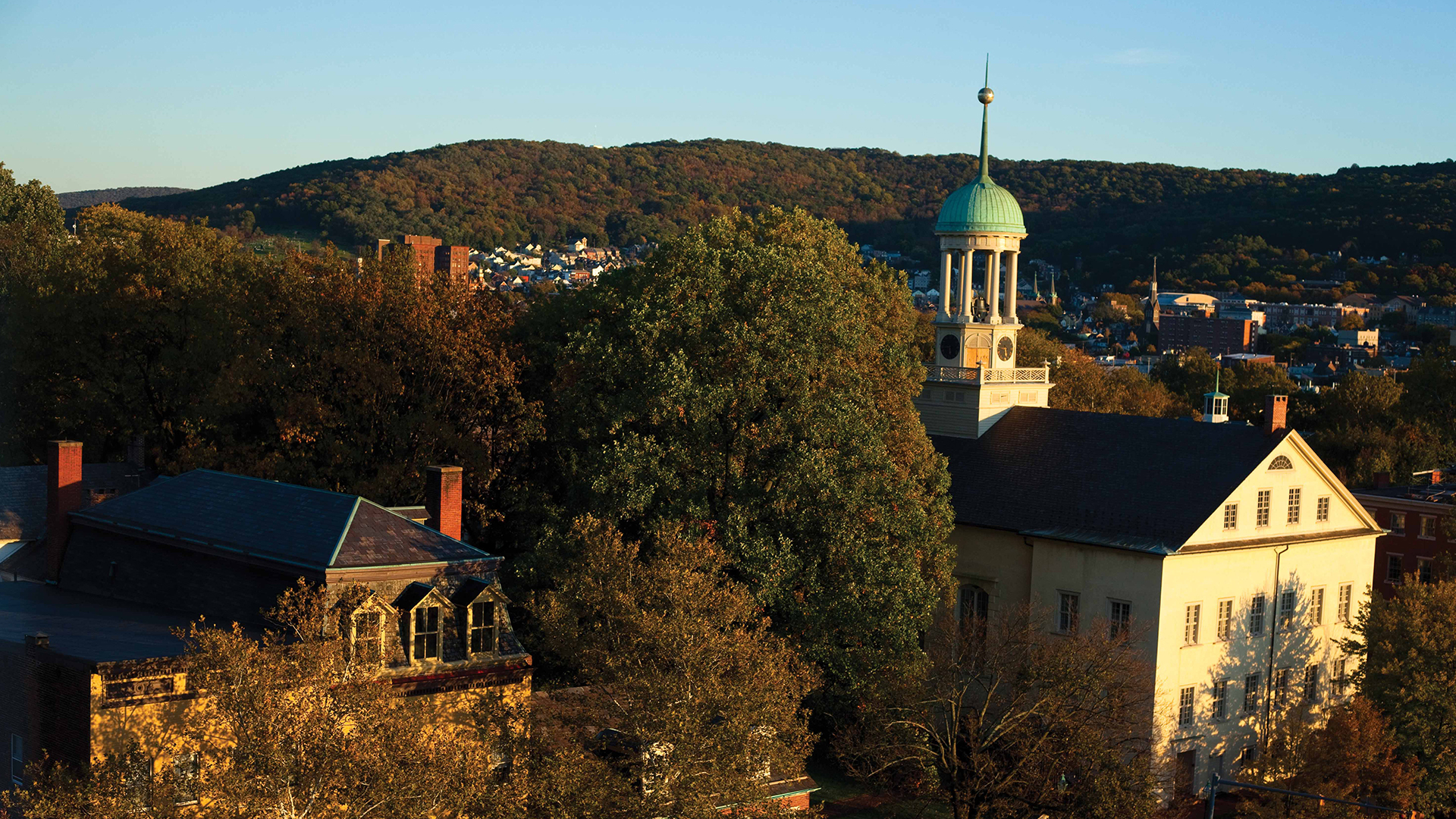 a building with a steeple and trees in the background