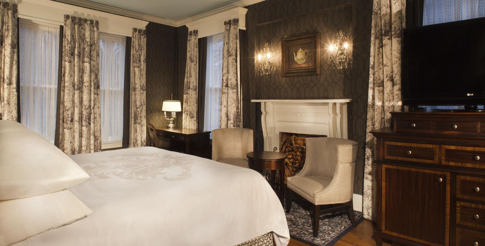 a room with a bed and chairs