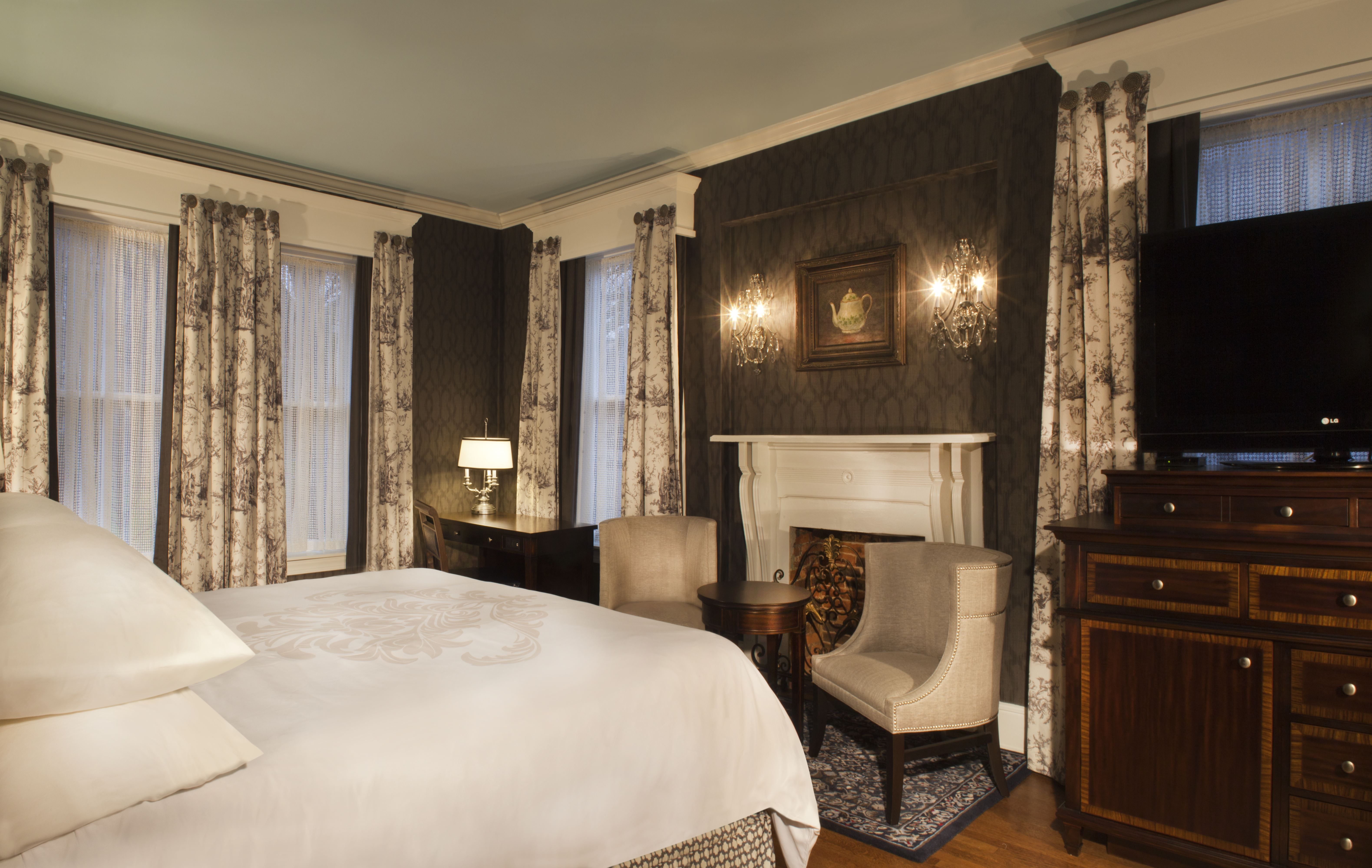 a room with a bed and chairs