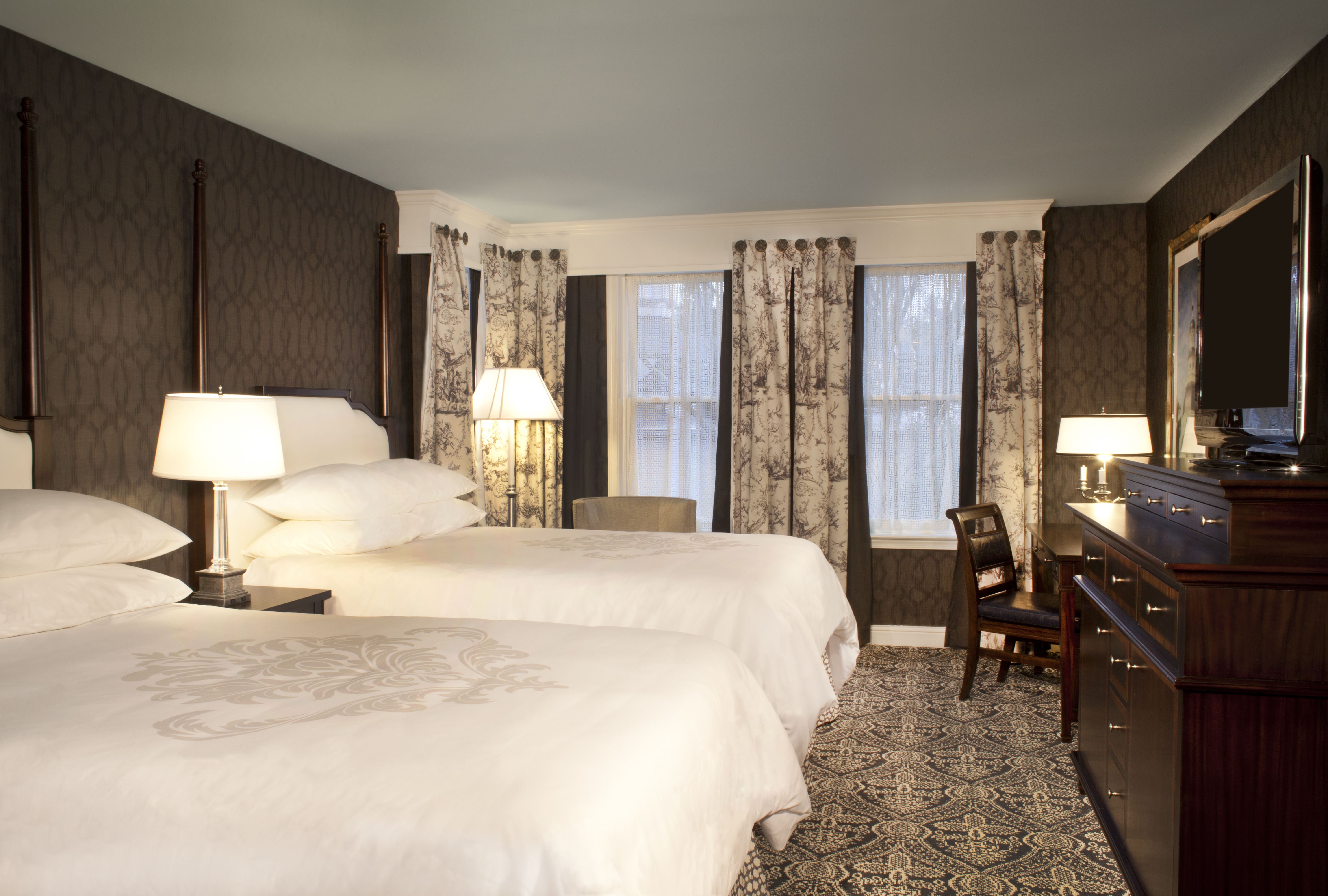 a room with two beds and a desk