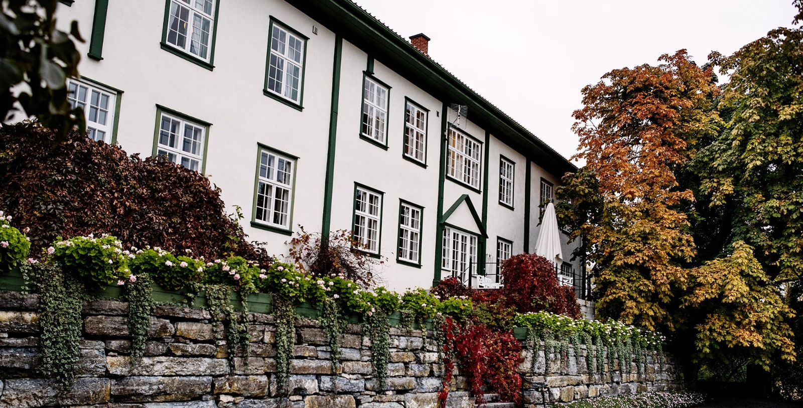 a building with a stone wall and plants