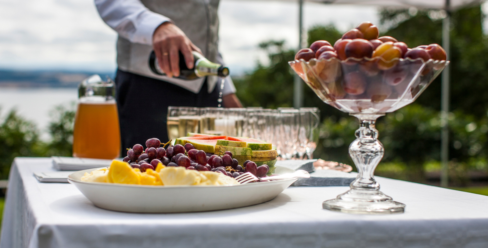 a man pouring champagne into a bowl of fruit