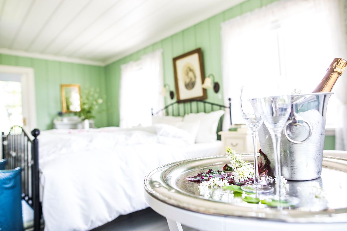a silver tray with wine glasses and flowers on it in a bedroom