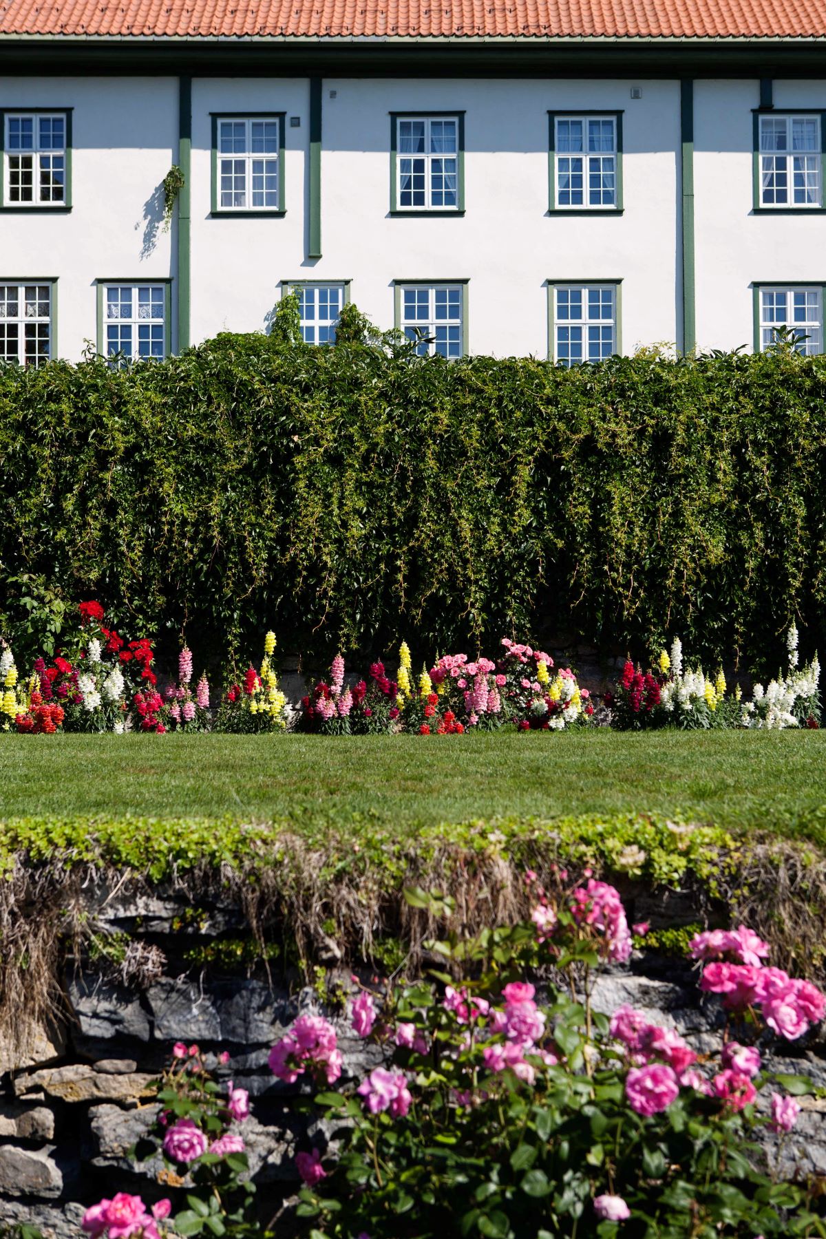 a building with a white wall and a flower bed