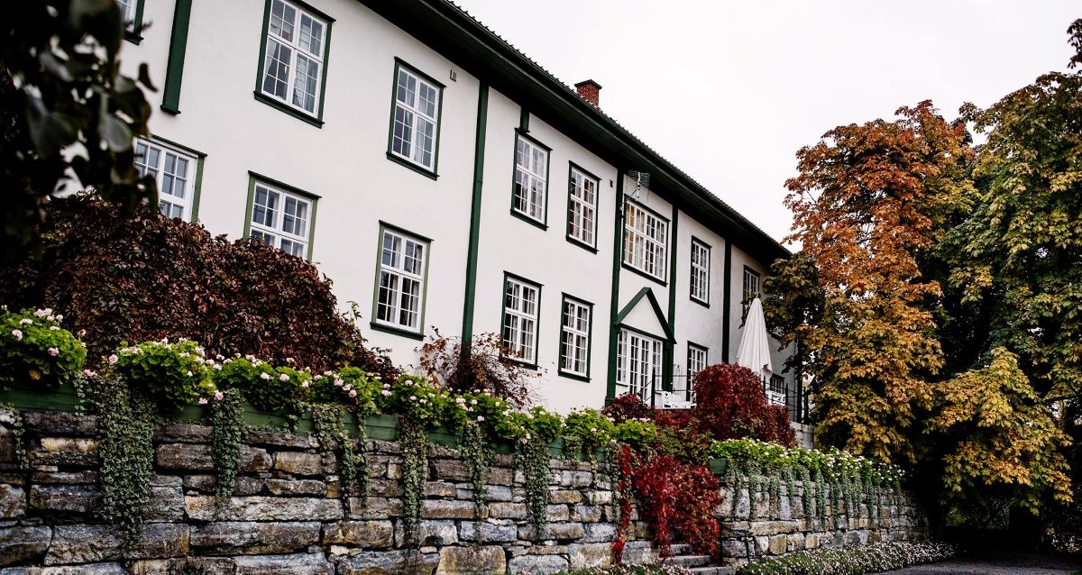 a building with a stone wall and trees