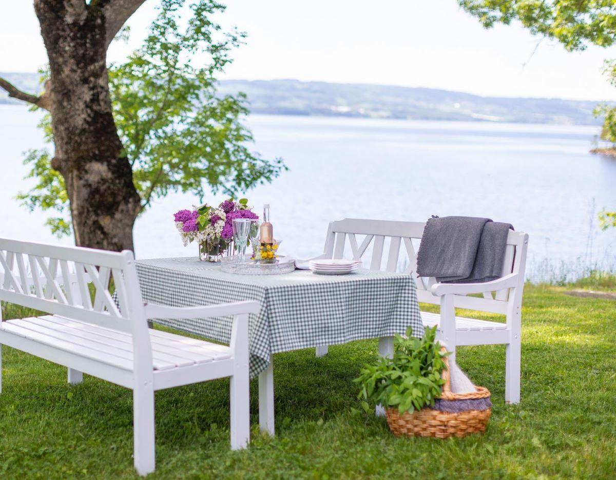 a table and chairs in a grassy area by a tree