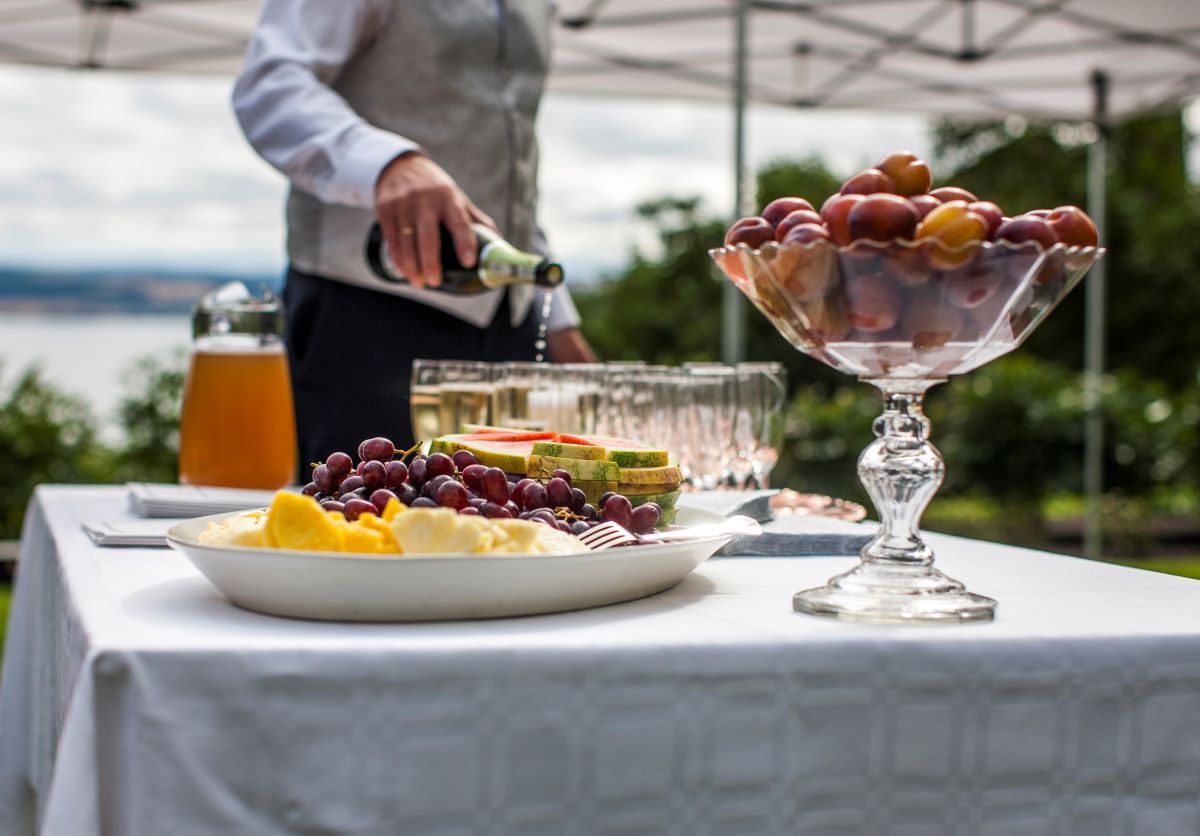 a table with fruit and wine glasses