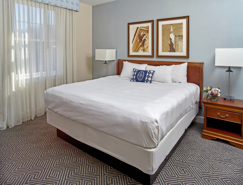 a bed with white sheets and a lamp
