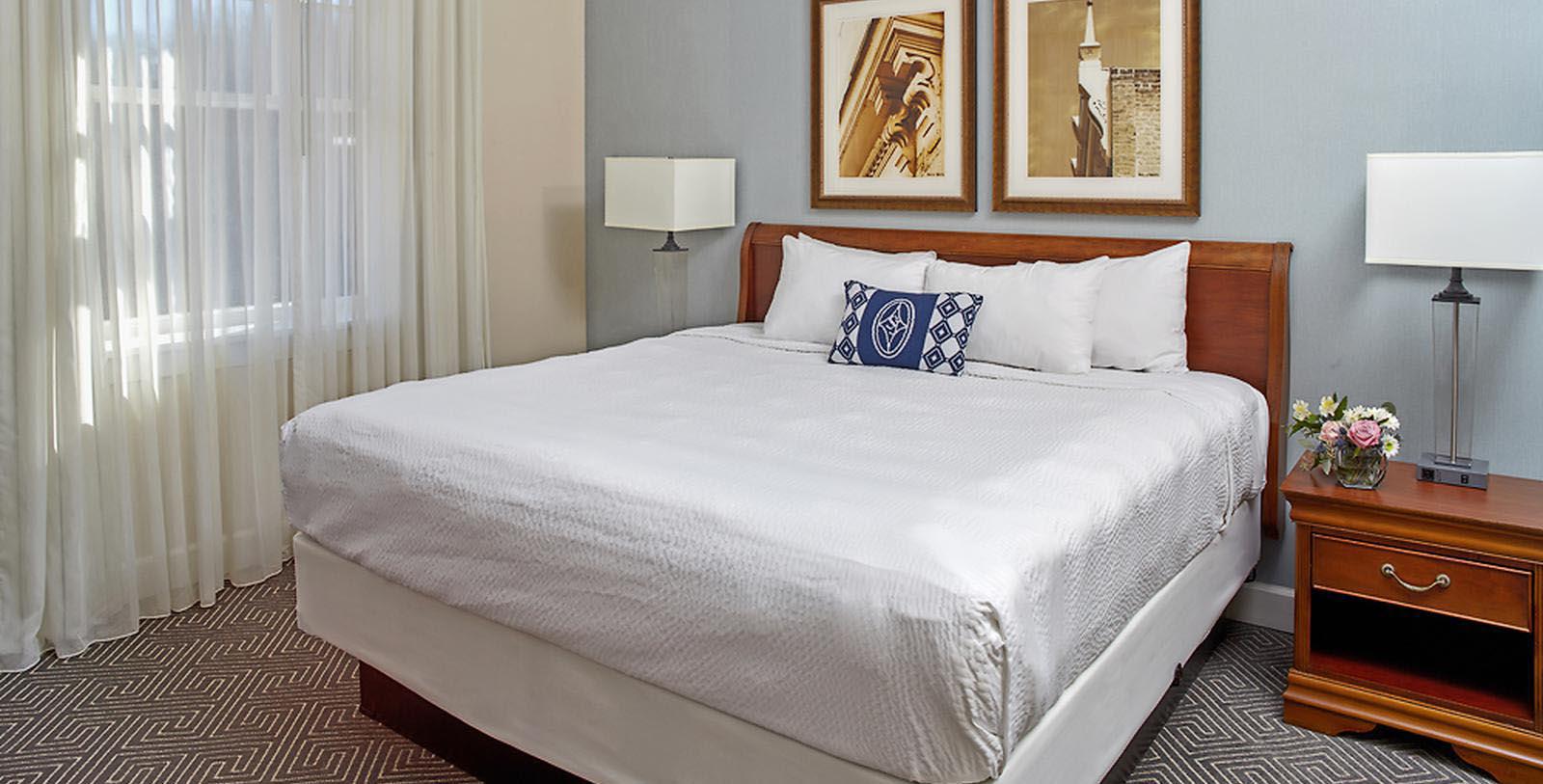 a bed with white sheets and a lamp