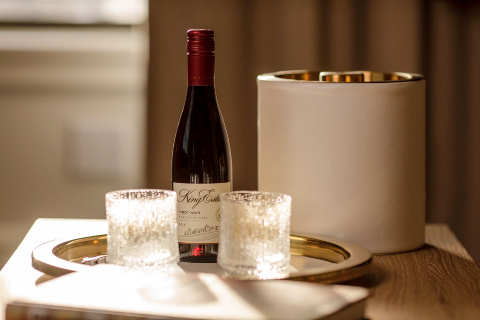 a bottle of wine and two candles on a tray