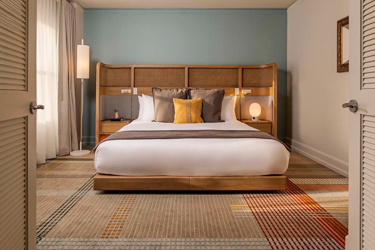 a bed with a headboard and lamps in a room