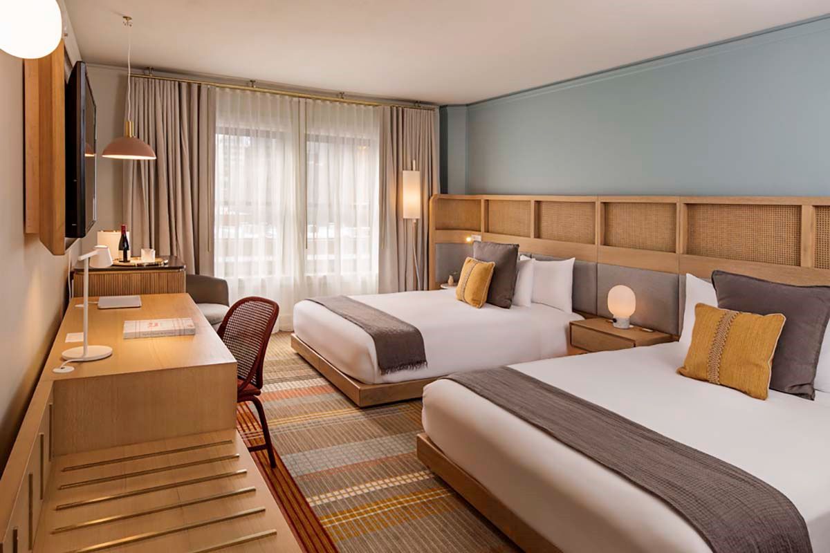 a room with two beds and a desk