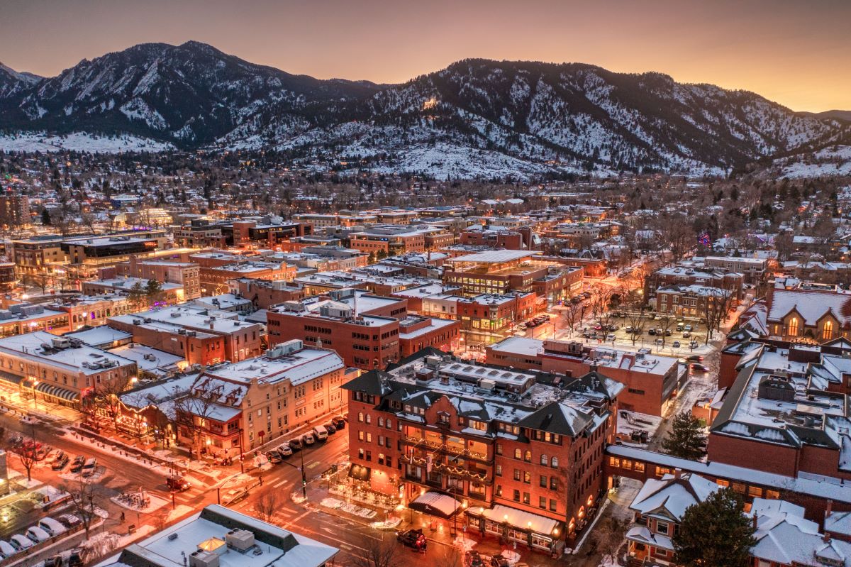 a city with snow covered buildings and mountains