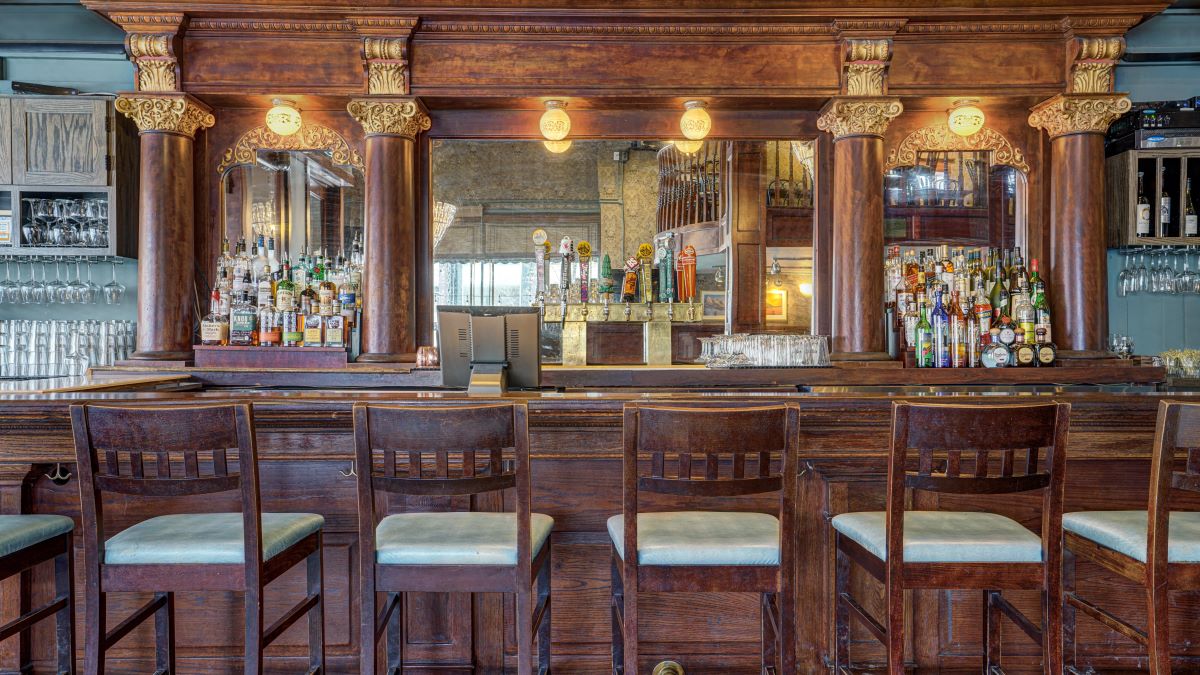 a bar with chairs and a mirror