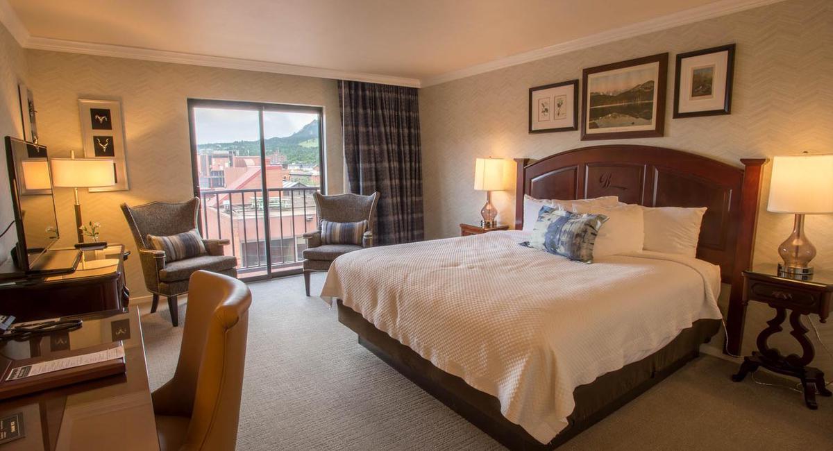 a bedroom with a bed and chairs