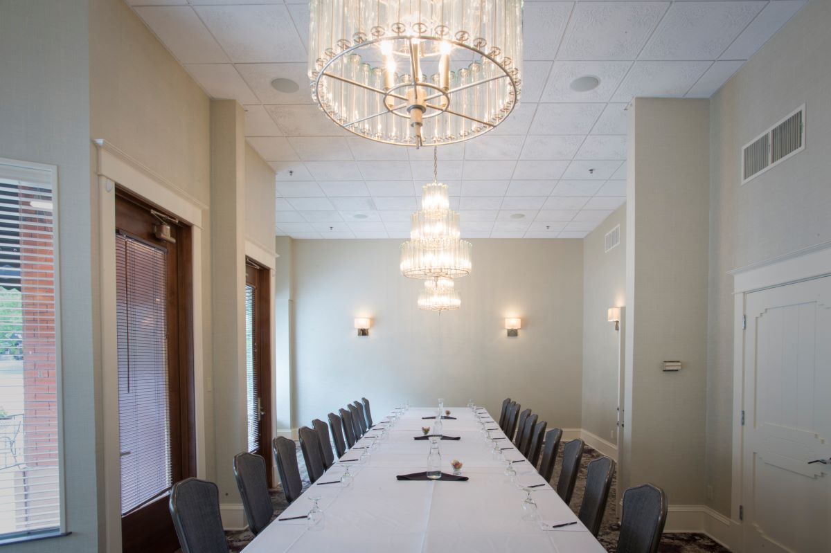 a long table with chairs and a chandelier