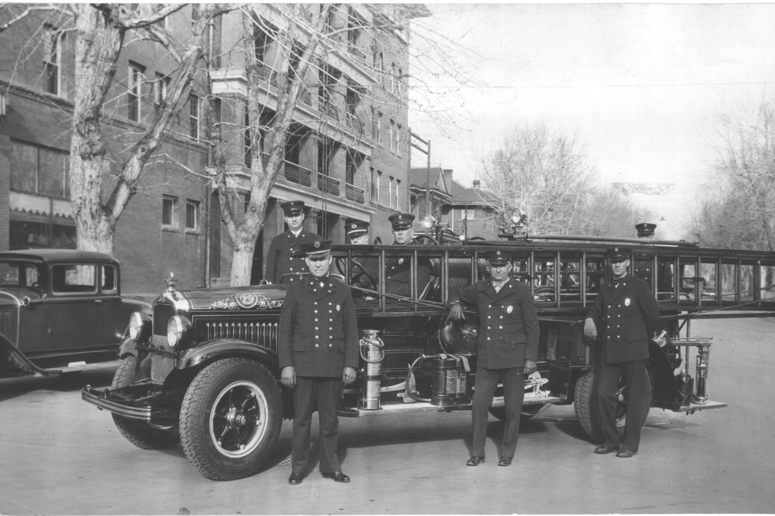 a group of men standing next to a fire truck