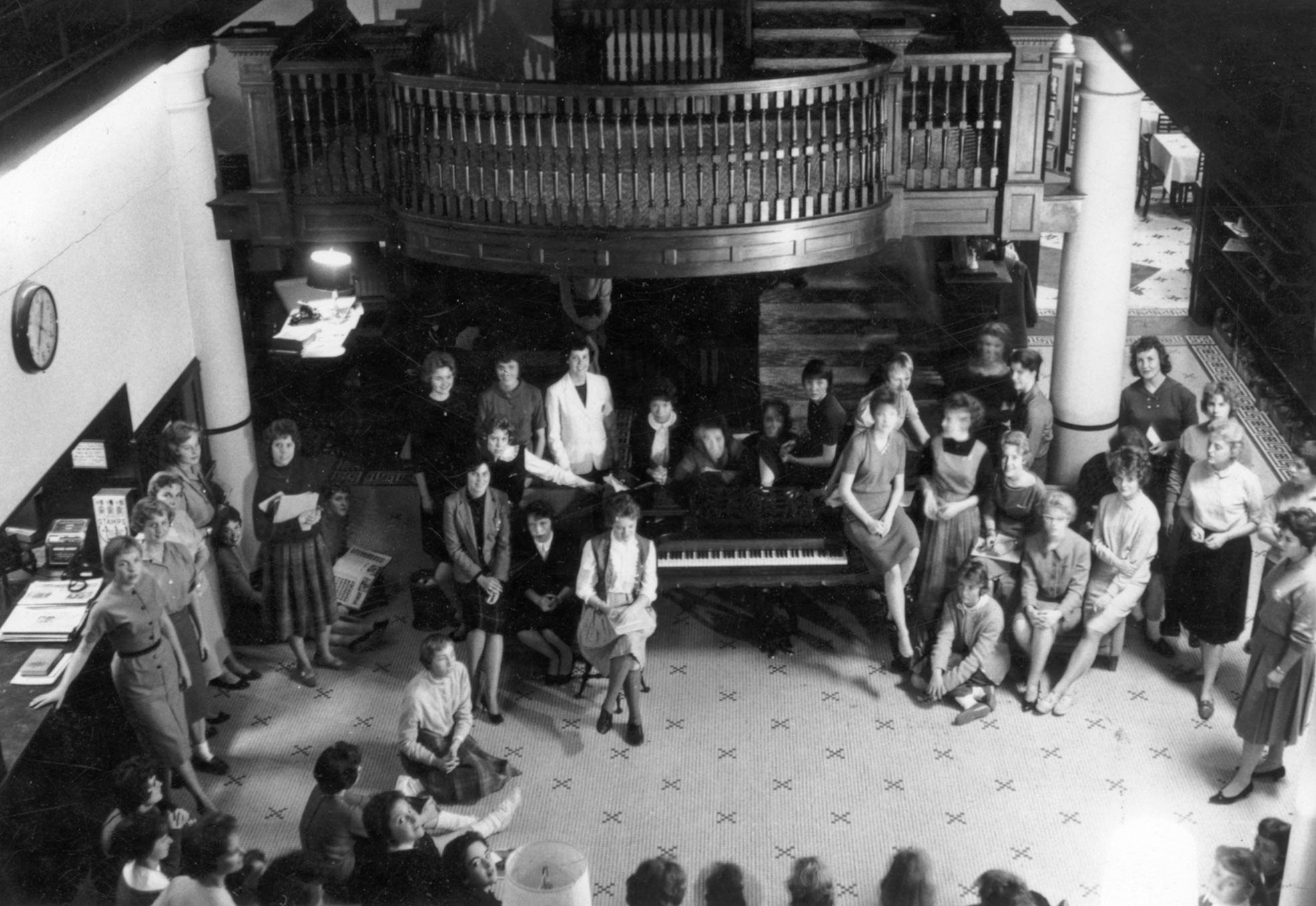 a group of people sitting around a piano
