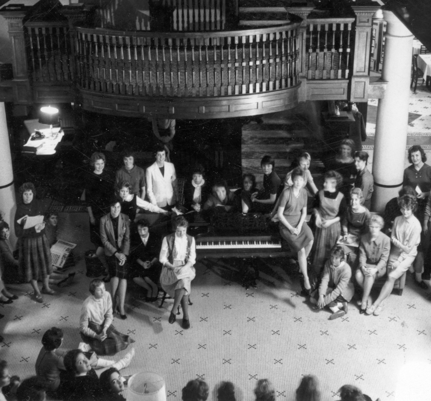 a group of people sitting around a piano