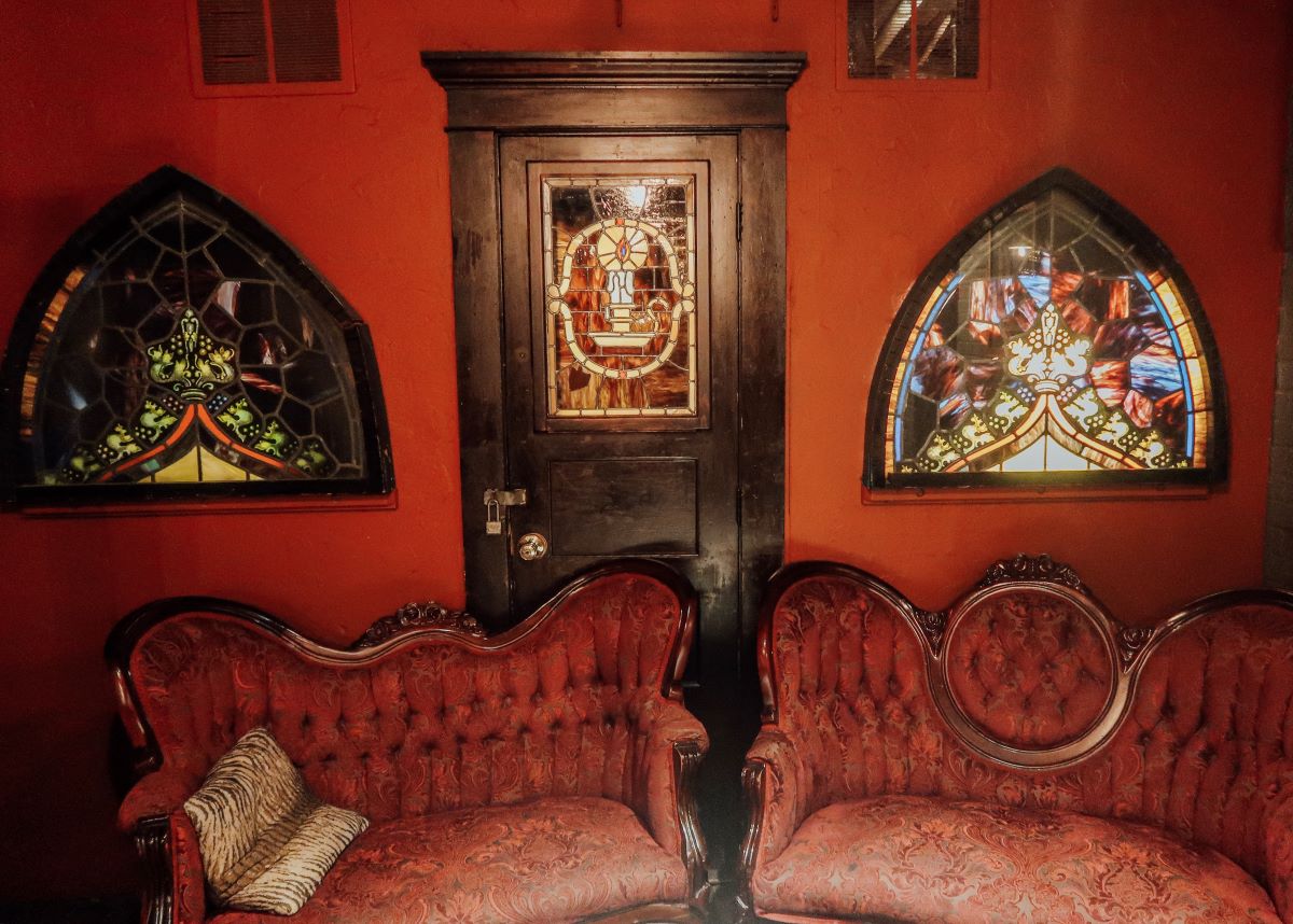 a red couches in a room with stained glass windows